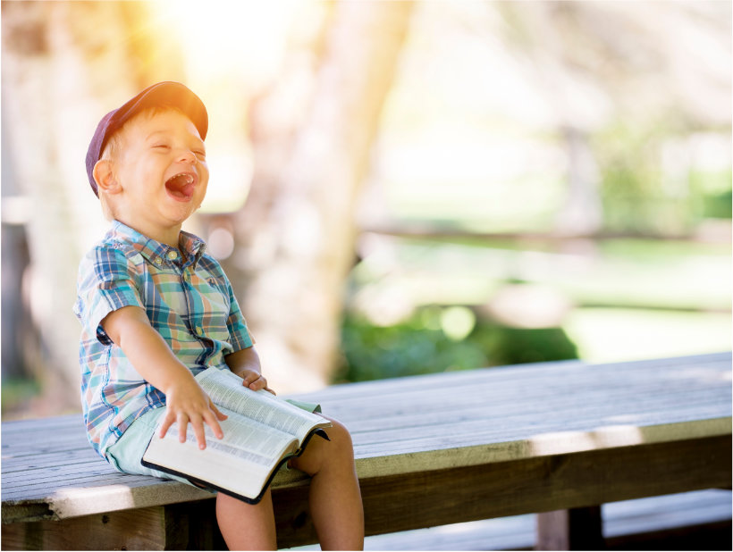 Un enfant heureux en lisant une histoire de la Bible